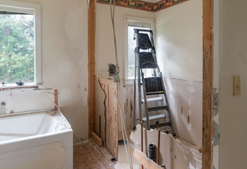 Professional bathroom remodeling process with safety equipment and quality inspection